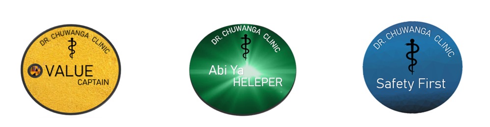 Three circular Luxian badges: Value Captain, Helper, and Safety First, each bearing the Dr Chuwanga Clinic Rod of Asclepius emblem